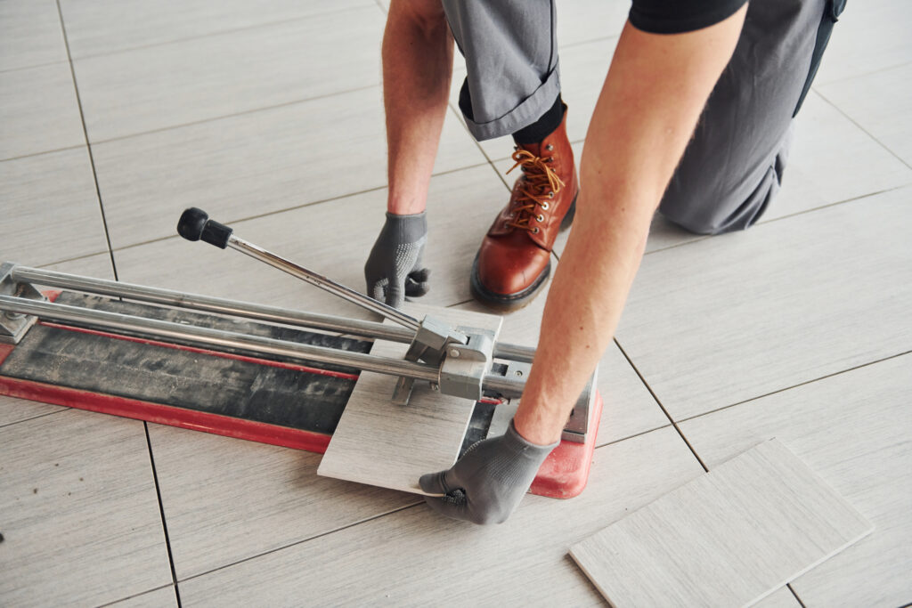 Man in grey uniform installing plate indoors in modern big office at daytime